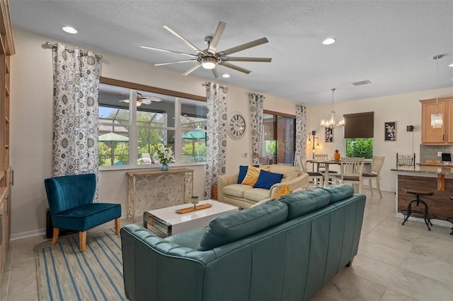 living room with recessed lighting, visible vents, a textured ceiling, and ceiling fan with notable chandelier