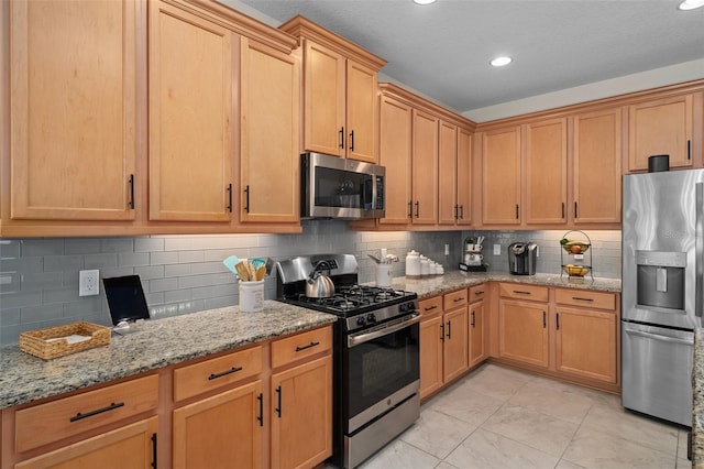 kitchen featuring light tile patterned floors, decorative backsplash, appliances with stainless steel finishes, light stone counters, and recessed lighting