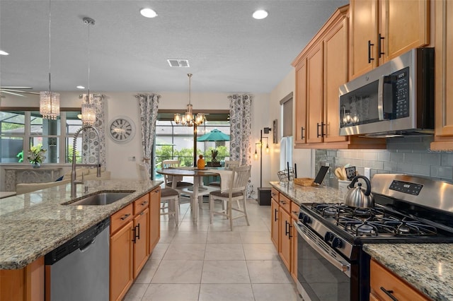 kitchen with light tile patterned floors, stainless steel appliances, decorative backsplash, a sink, and a chandelier