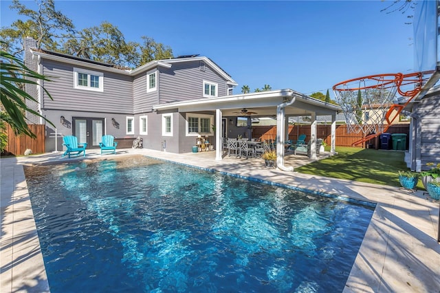 view of swimming pool with a fenced in pool, french doors, a lawn, a patio area, and a fenced backyard