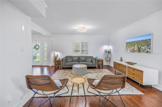 living area with a healthy amount of sunlight, ornamental molding, and hardwood / wood-style floors