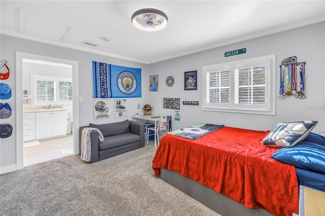 bedroom featuring carpet floors, crown molding, visible vents, attic access, and ensuite bath