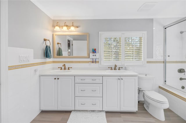 bathroom featuring toilet, tile walls, and a sink