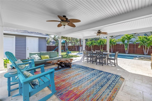 view of patio / terrace featuring an outdoor living space with a fire pit, a fenced backyard, ceiling fan, a playground, and outdoor dining space