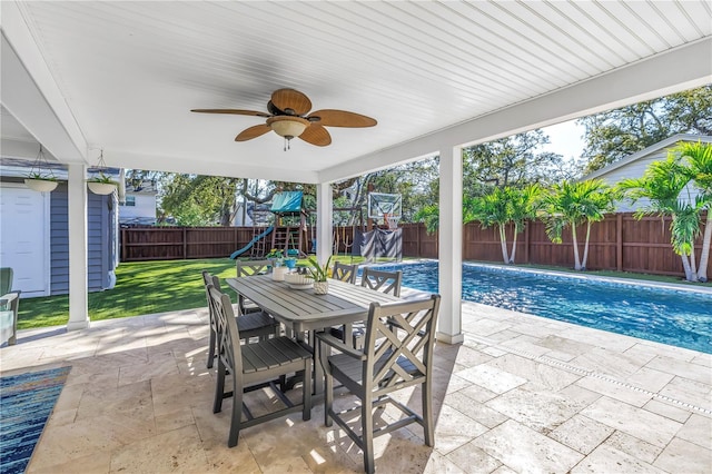 view of patio / terrace featuring a ceiling fan, a fenced in pool, a fenced backyard, outdoor dining area, and a playground