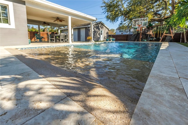 view of swimming pool featuring a fenced in pool, fence, a ceiling fan, and a patio