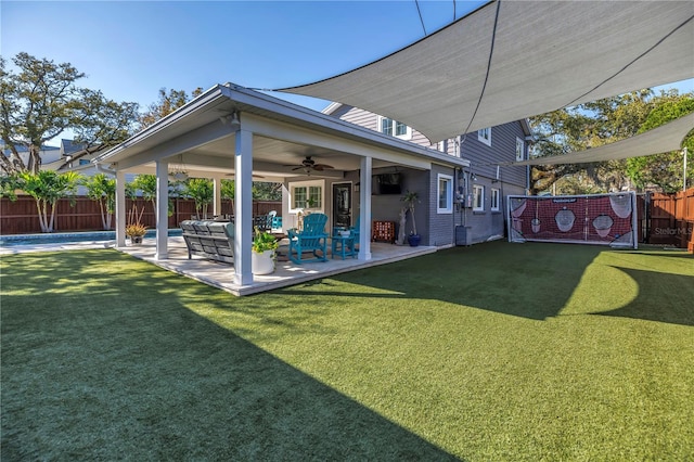 view of yard with a fenced backyard, ceiling fan, and a patio