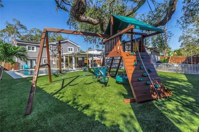 view of jungle gym with a yard, a fenced in pool, and fence