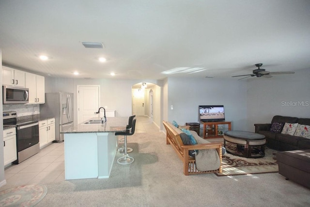 living area featuring light tile patterned floors, visible vents, arched walkways, ceiling fan, and recessed lighting