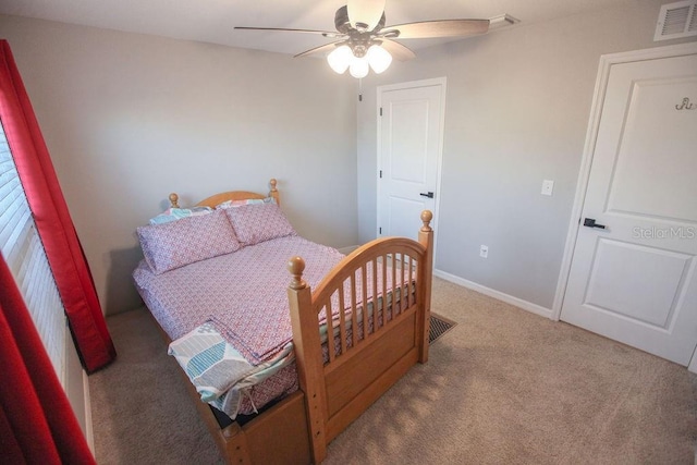 carpeted bedroom with baseboards, visible vents, and ceiling fan