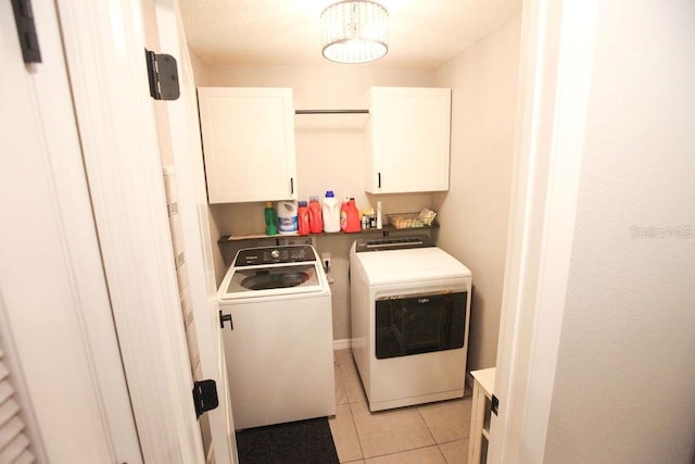 washroom with cabinet space, light tile patterned floors, and washer and dryer