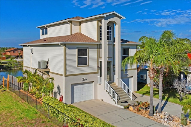 view of front of home with central air condition unit, a garage, fence, driveway, and stucco siding