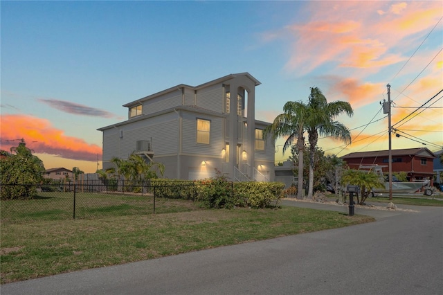 view of front of home with a yard and fence