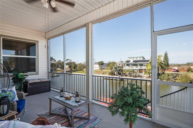 sunroom / solarium with a water view and ceiling fan