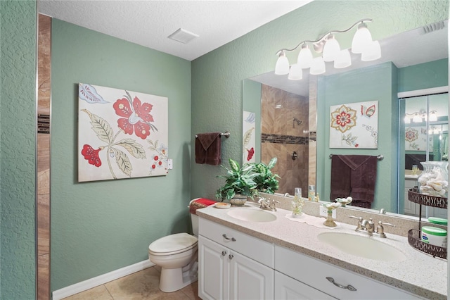 full bath featuring a tile shower, a sink, visible vents, and tile patterned floors