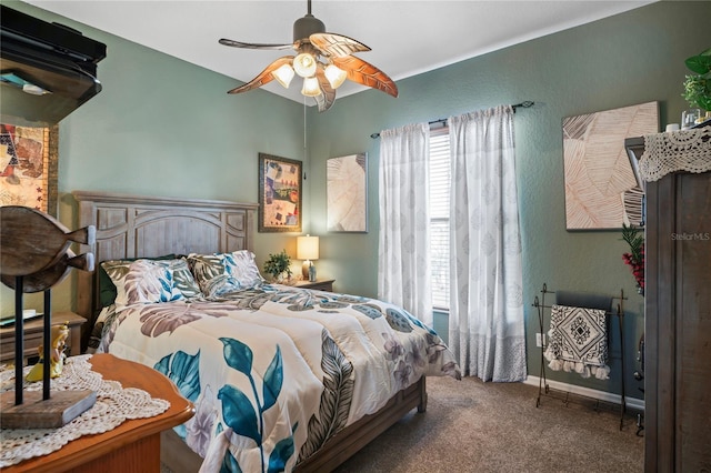 carpeted bedroom with ceiling fan and baseboards