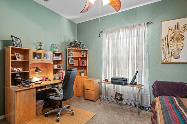 office space with light colored carpet, a textured wall, and ceiling fan