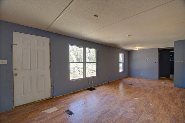 empty room featuring wood finished floors and visible vents