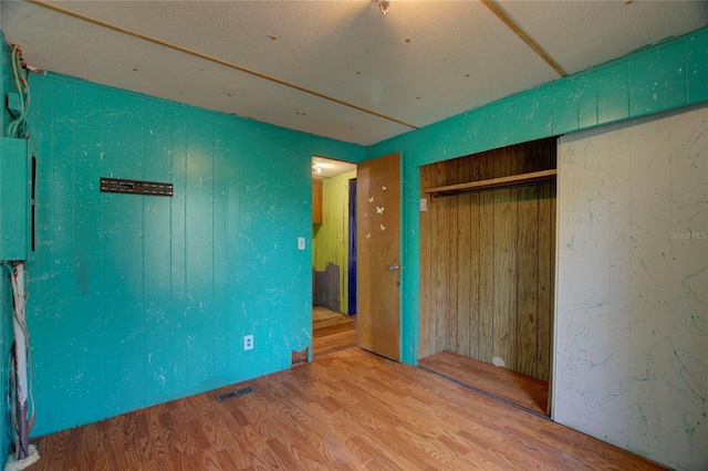 unfurnished bedroom with a closet, visible vents, and wood finished floors