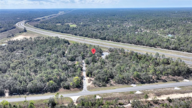 birds eye view of property featuring a forest view