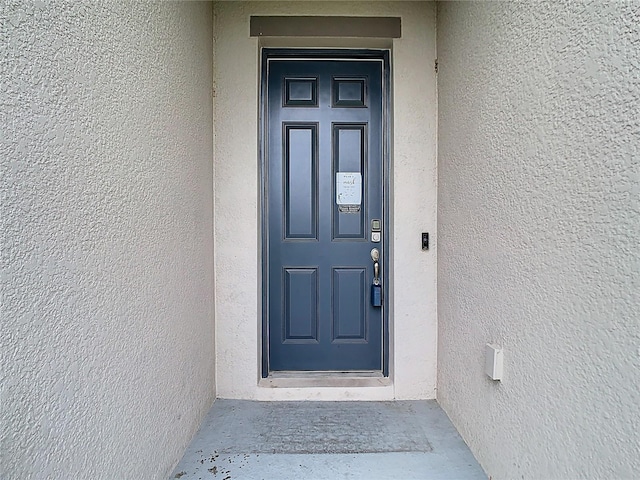 view of exterior entry featuring stucco siding