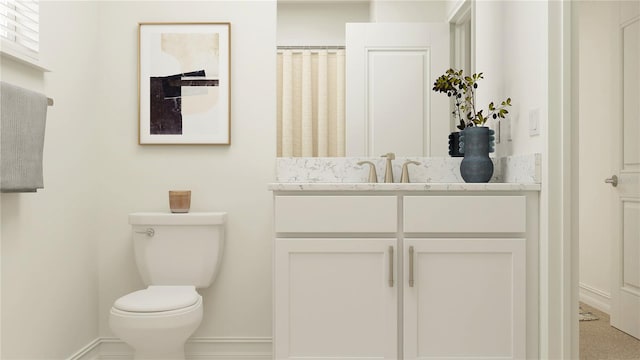 bathroom featuring toilet, baseboards, and vanity