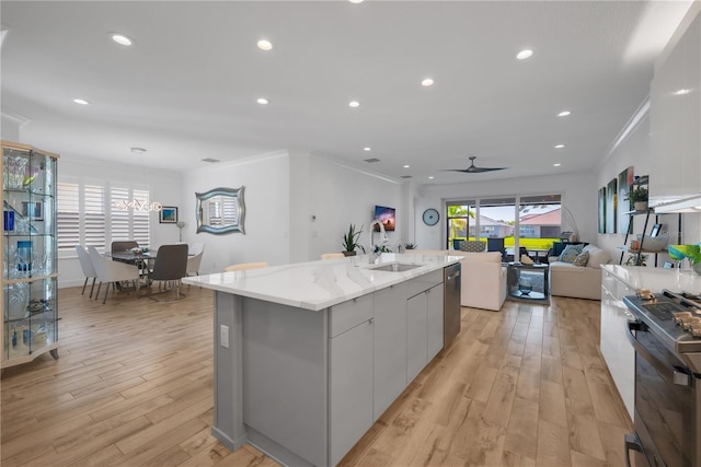 kitchen featuring light wood finished floors, appliances with stainless steel finishes, plenty of natural light, and a sink