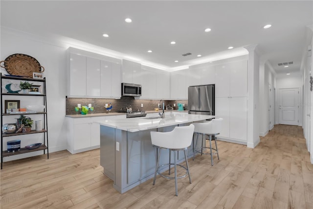 kitchen featuring stainless steel appliances, white cabinets, visible vents, and modern cabinets