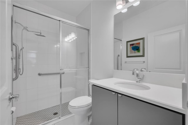 bathroom with toilet, a stall shower, and vanity