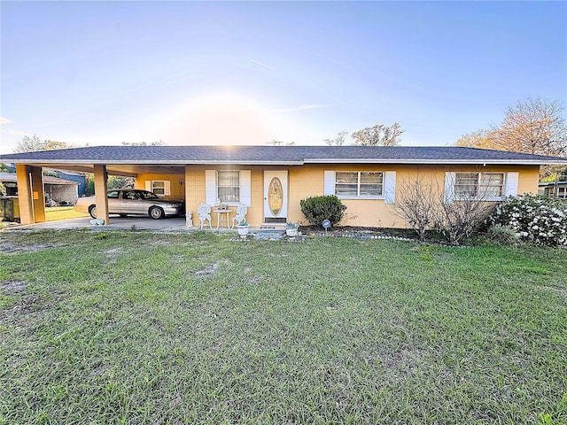 ranch-style home with a carport and a front yard