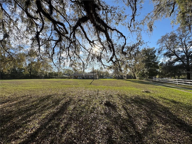 view of yard featuring a rural view and fence