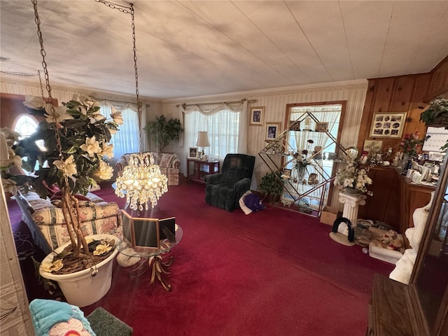 carpeted living room with wood walls and ornamental molding