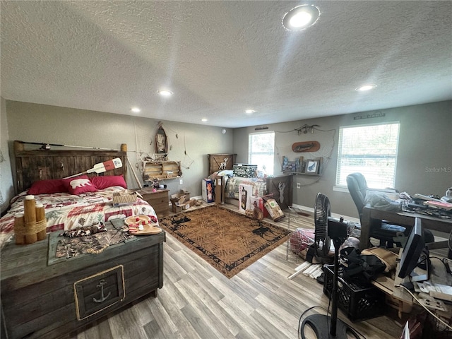 bedroom featuring recessed lighting, a textured ceiling, baseboards, and wood finished floors