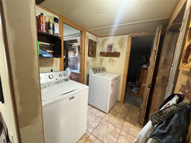 clothes washing area featuring a textured ceiling, laundry area, and separate washer and dryer