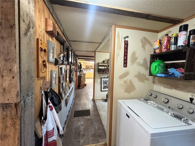 washroom featuring washer / dryer, a textured ceiling, laundry area, and wood finished floors
