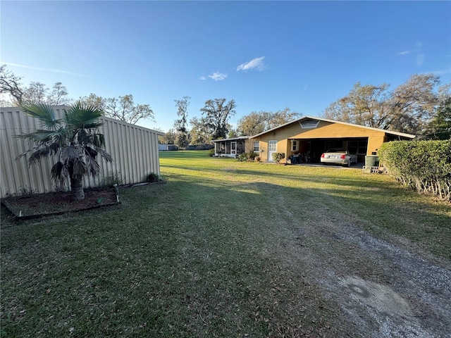 view of yard featuring driveway and a carport