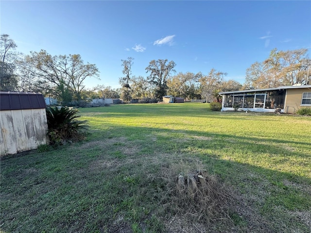 view of yard with a storage shed, a sunroom, and an outdoor structure