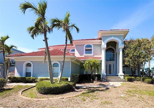 mediterranean / spanish-style house featuring french doors, a tile roof, and stucco siding