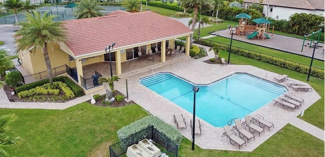 pool with playground community, a lawn, a patio area, and fence