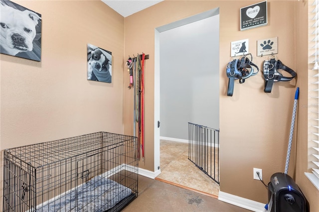 hall with concrete flooring and baseboards