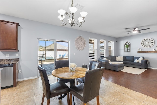 dining space featuring ceiling fan with notable chandelier, visible vents, baseboards, and light tile patterned floors