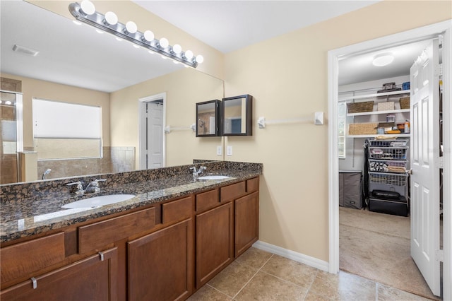 bathroom with double vanity, visible vents, a sink, and tile patterned floors