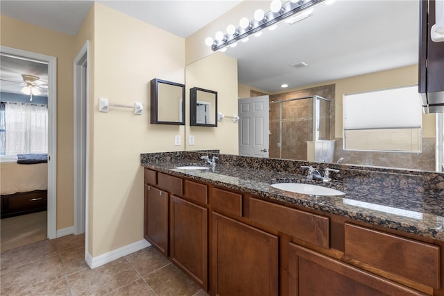 ensuite bathroom with tile patterned flooring, a shower stall, connected bathroom, and a sink