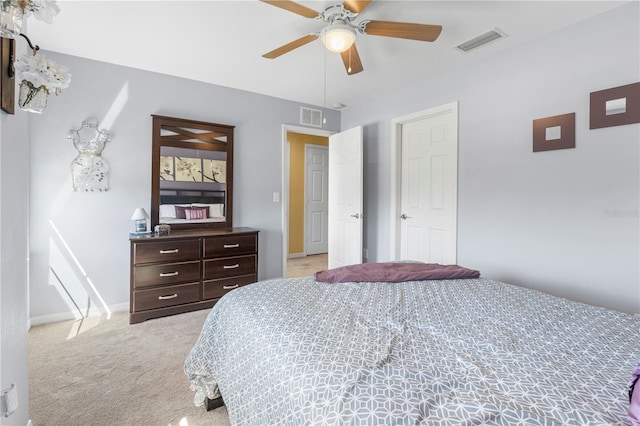 bedroom with a ceiling fan, light colored carpet, visible vents, and baseboards