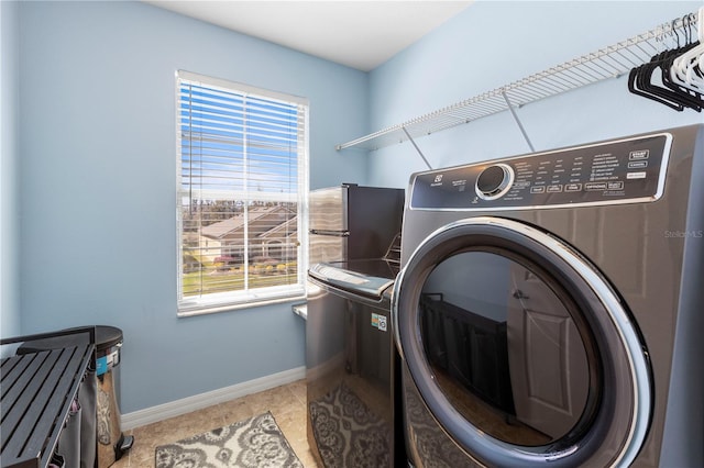 washroom with laundry area, plenty of natural light, washing machine and clothes dryer, and baseboards