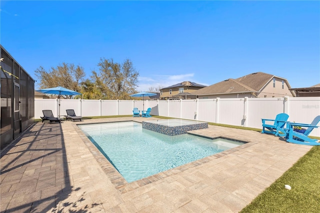 view of pool featuring a patio area, a fenced backyard, and a pool with connected hot tub