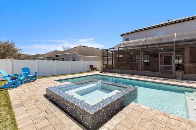 view of pool featuring a pool with connected hot tub, a lanai, a fenced backyard, and a patio