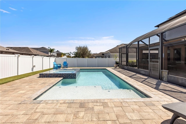 view of pool with glass enclosure, a patio area, a fenced backyard, and a pool with connected hot tub