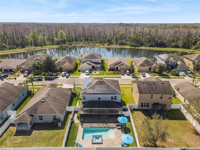 birds eye view of property featuring a water view, a wooded view, and a residential view