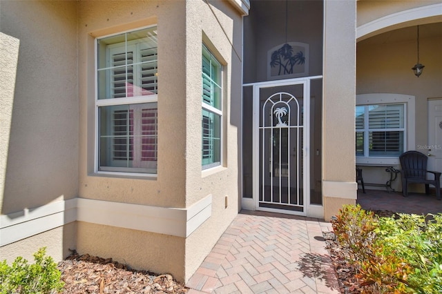 doorway to property featuring stucco siding